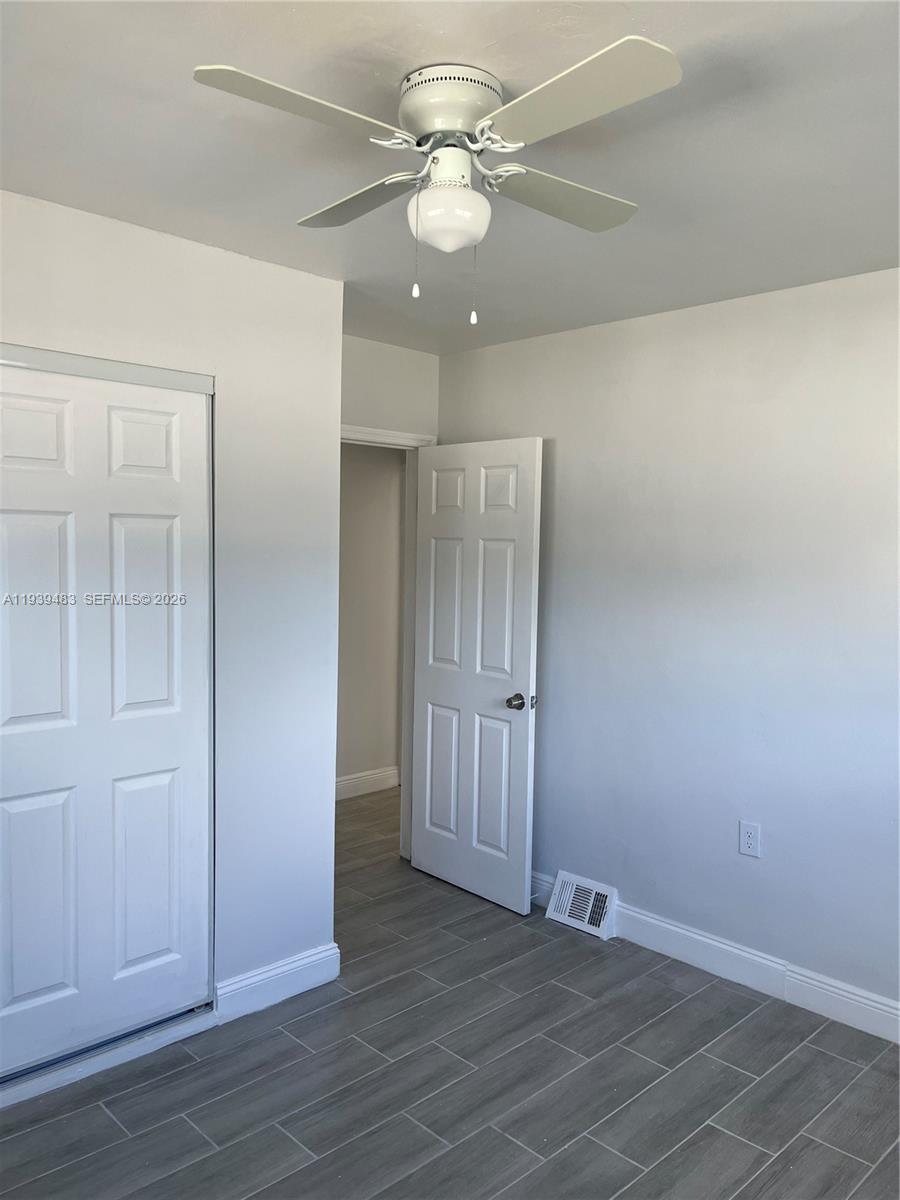 1386 Northwest 38th Street, Unit 1 Miami, FL 33142 - Photo 6 of 6 an empty room with wooden floor and fan