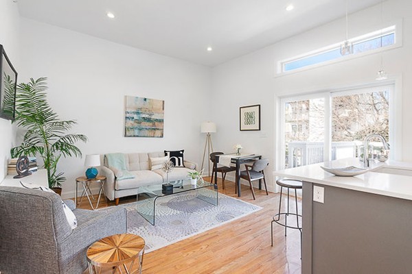 a living room with furniture wooden floor and a large window