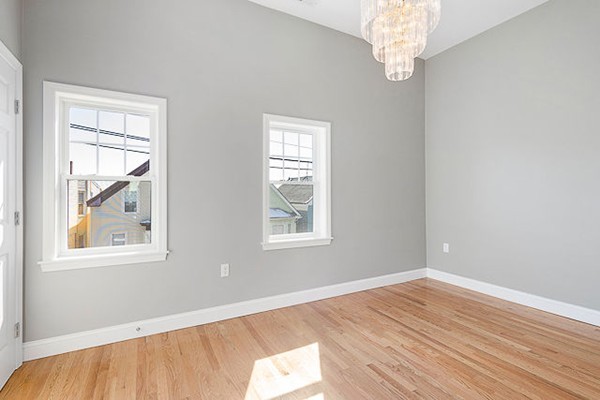 126 Princeton Street, Unit 3 Boston, MA 02128 - Photo 4 of 8 a view of empty room with wooden floor and fan