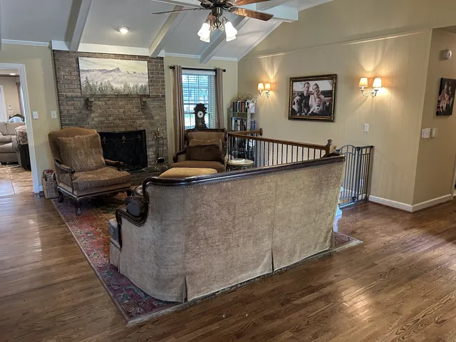a living room with furniture a large window and a fireplace