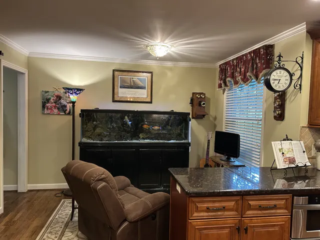 a kitchen with stainless steel appliances granite countertop a refrigerator a stove a sink a dining table and chairs