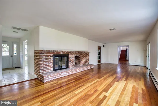 a view of empty room with wooden floor and fireplace