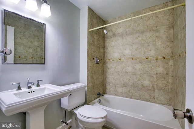 a bathroom with a sink mirror toilet and bathtub