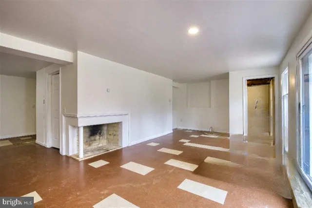 a view of an empty room with window and fire place