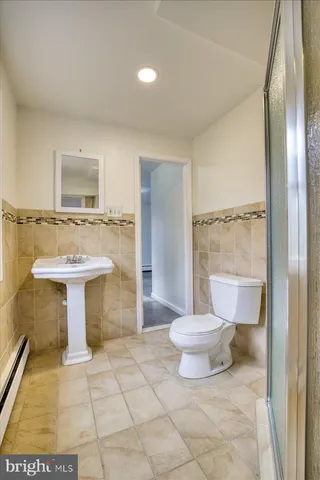 a bathroom with a sink toilet a mirror and shower
