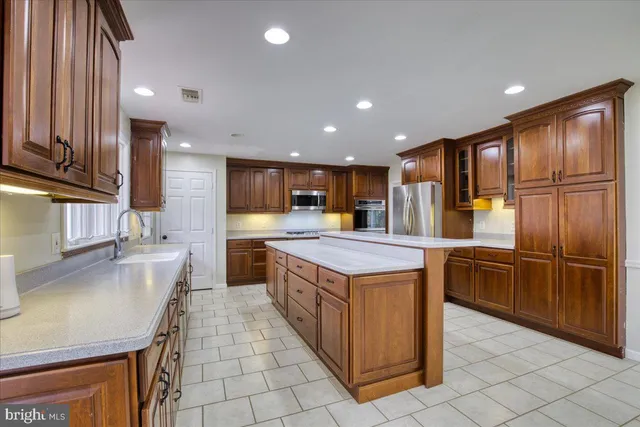 a kitchen with kitchen island granite countertop wooden cabinets a sink and dishwasher