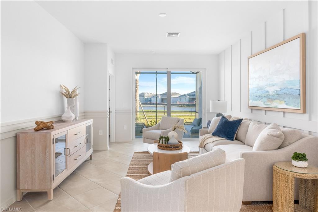 Living room with light tile patterned flooring and a water view