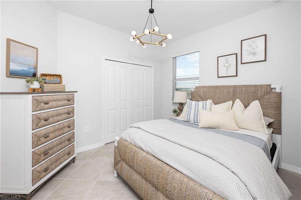 14888 Anchorage Road Punta Gorda, FL 33982 - Photo 11 of 34 Bedroom with a chandelier, a closet, and light tile patterned floors