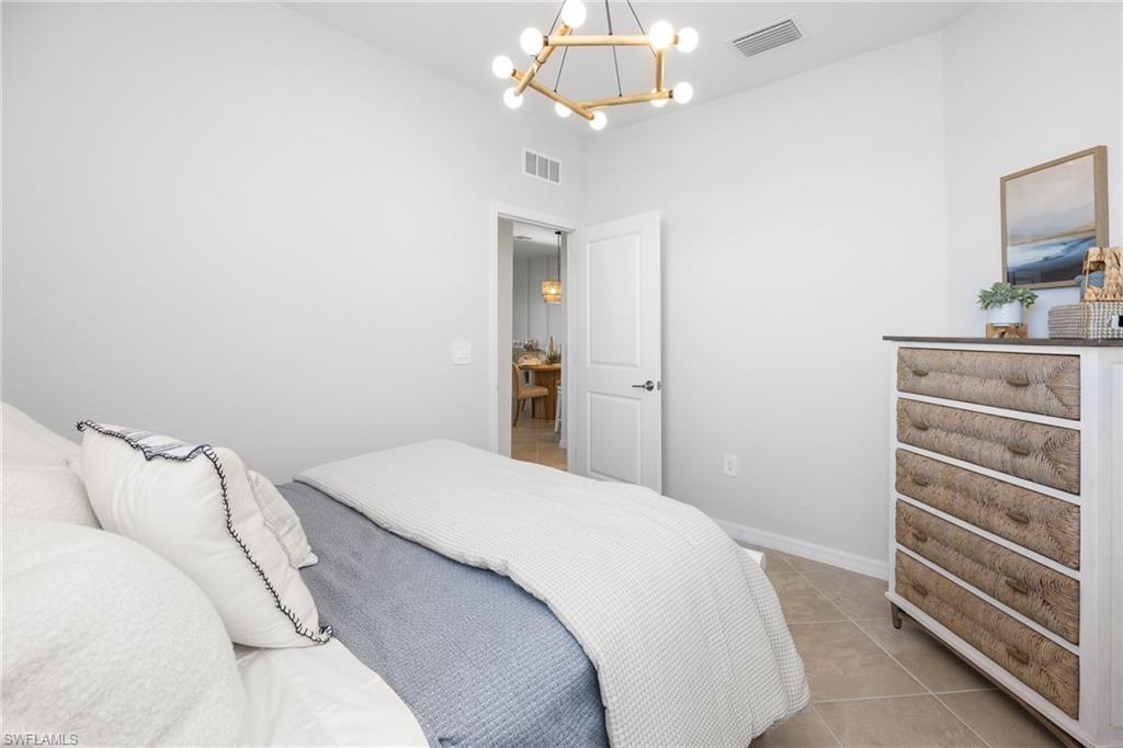 14888 Anchorage Road Punta Gorda, FL 33982 - Photo 12 of 34 Bedroom with a chandelier and light tile patterned floors