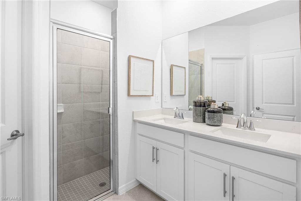 14888 Anchorage Road Punta Gorda, FL 33982 - Photo 18 of 34 Bathroom with a stall shower, double vanity, and tile patterned floors