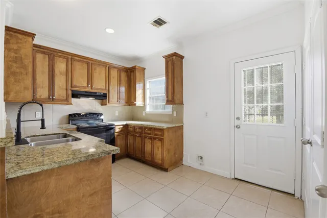 a kitchen with stainless steel appliances granite countertop a stove a sink and a refrigerator