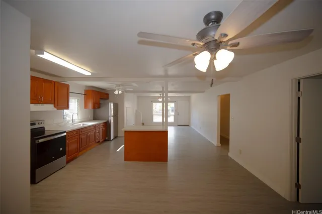a large kitchen with stainless steel appliances granite countertop a lot of counter space and a sink