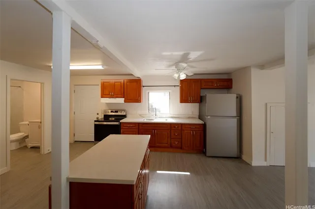 a kitchen with a refrigerator a sink dishwasher with a dining table and chairs