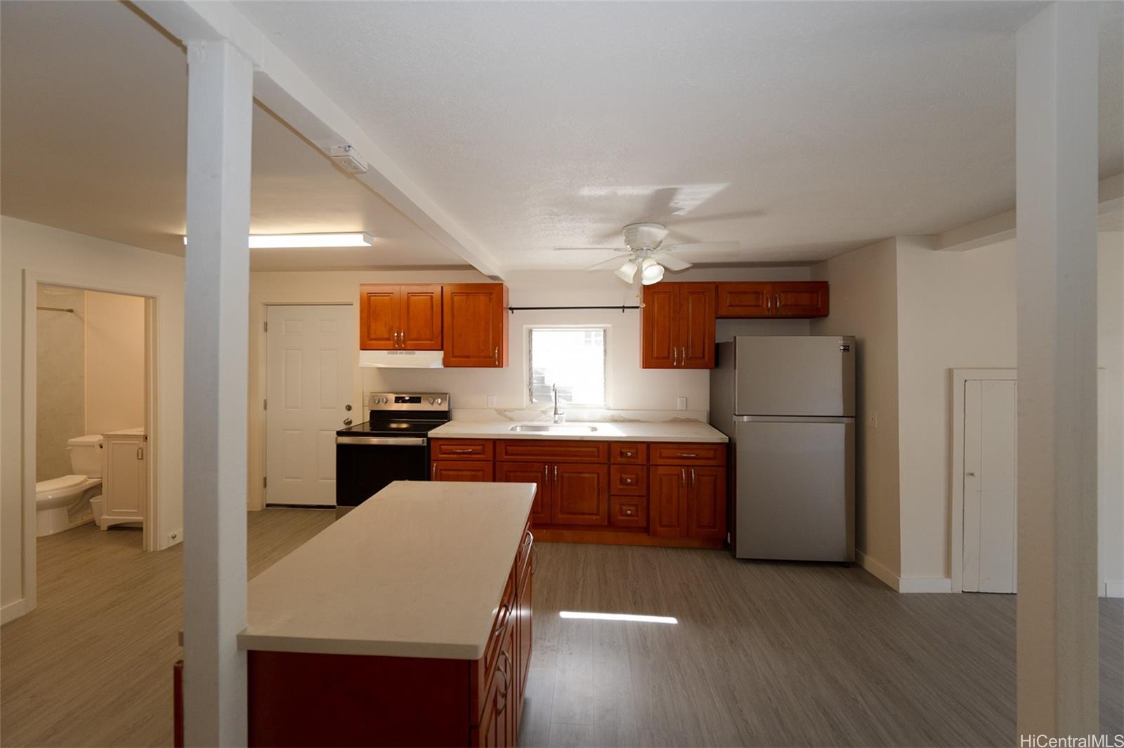 1513 Palolo Avenue Honolulu, HI 96816 - Photo 3 of 10 a kitchen with a refrigerator a sink dishwasher with a dining table and chairs