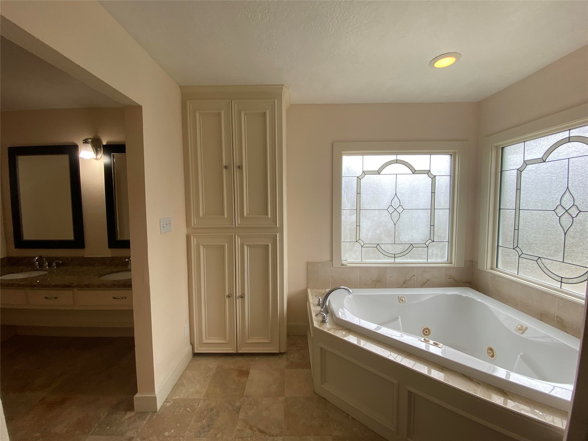 911 Hawthorne Road Clear Lake Shores, TX 77565 - Photo 19 of 50 And WOW!....This Gorgeous Master Bathroom Continues To The Corner Jetted Tub Framed By Decorative Windows, Separate Over-Sized Travertine Frameless Shower With Rain Shower Head And Bench Seat, And Built Ins!