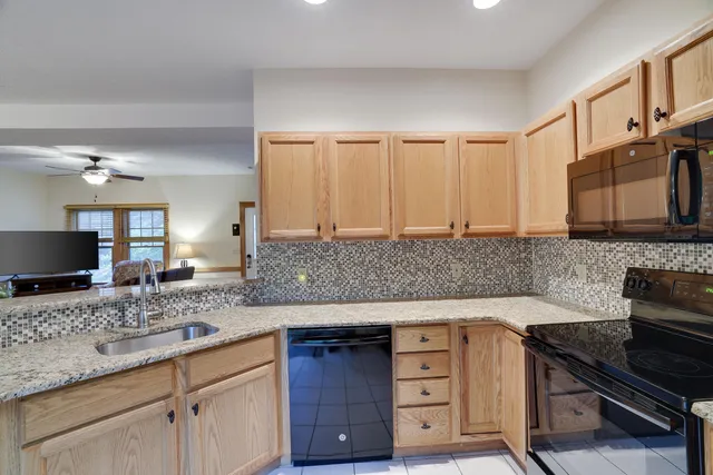 a kitchen with granite countertop a sink and a stove