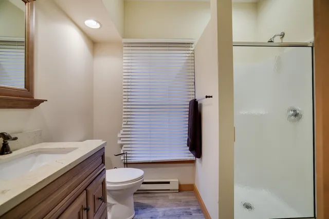 a bathroom with a sink a toilet and shower