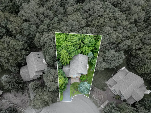 an aerial view of a house with a yard and green space