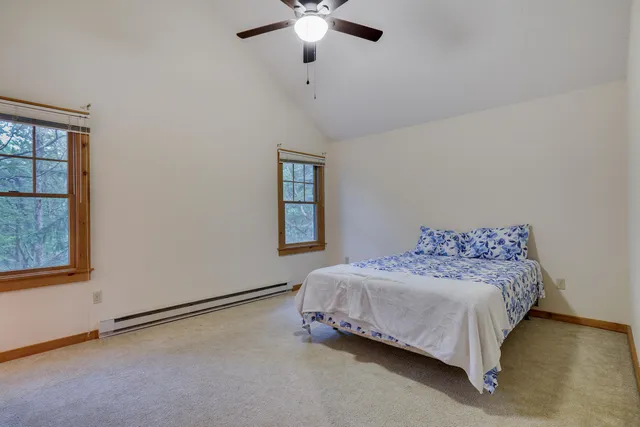 a bedroom with a bed chandelier and a window
