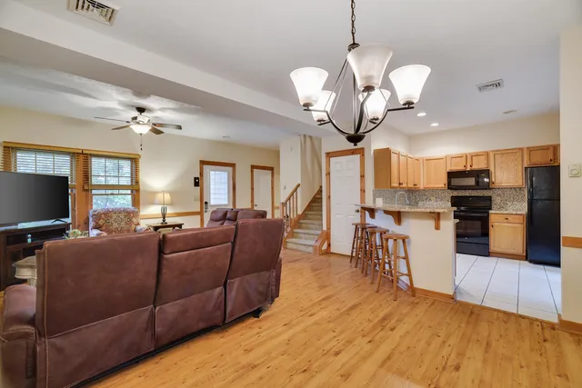 a living room with furniture chandelier and a flat screen tv