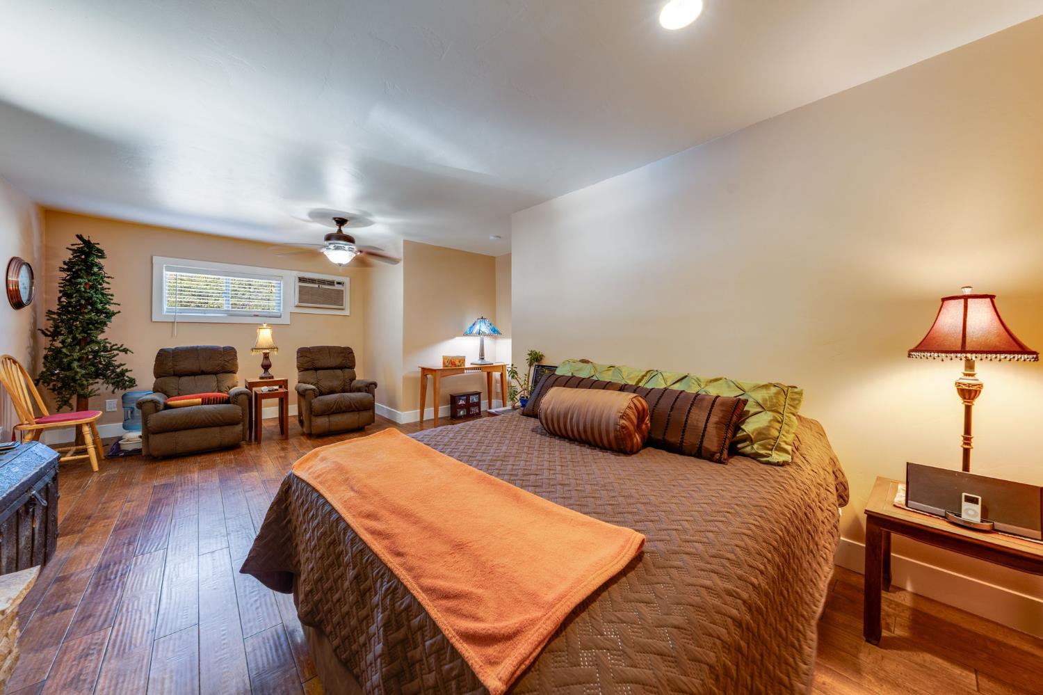 4600 El Caminito Road Shingle Springs, CA 95682 - Photo 48 of 76 a spacious bedroom with a bed a couch and dresser in it