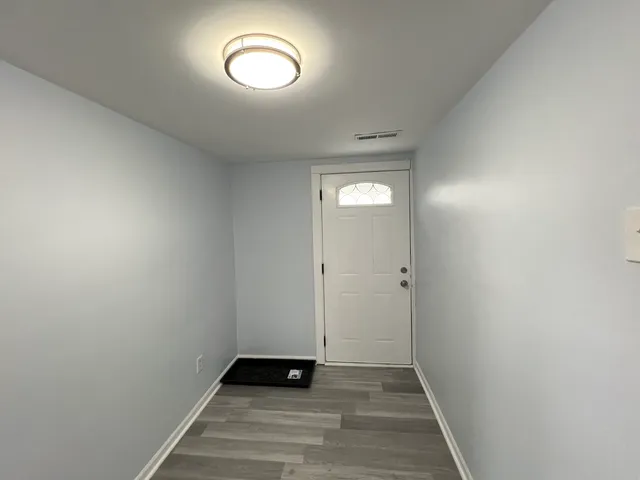 a view of a room with wooden floor and a window