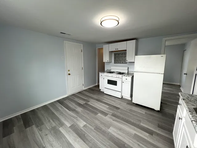 a view of kitchen with wooden floor and electronic appliances