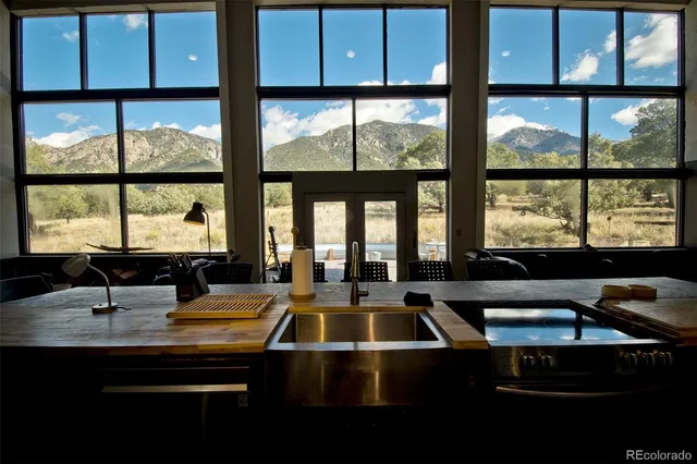 a kitchen with large window a sink and wooden cabinets