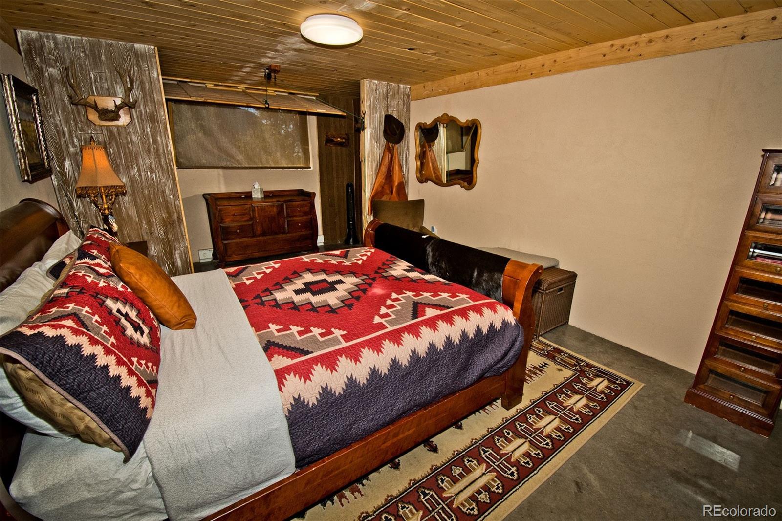 5 North Baca Grant Way Crestone, CO 81131 - Photo 27 of 42 a bedroom with a bed and wooden floor