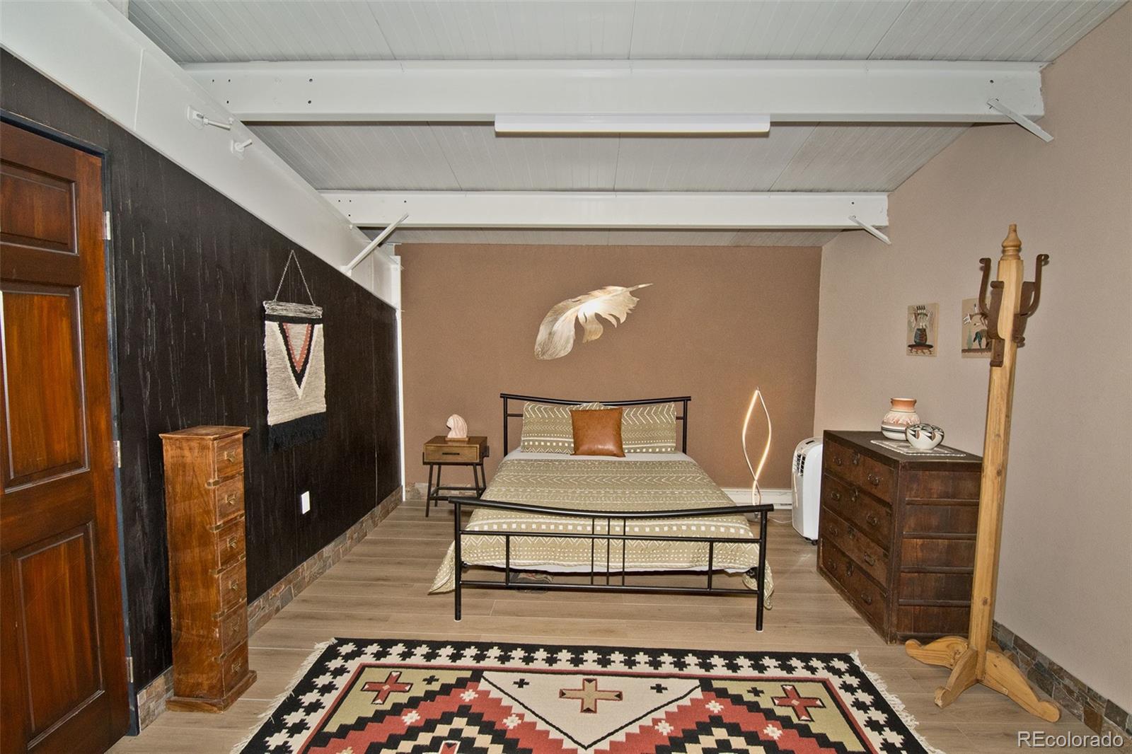 5 North Baca Grant Way Crestone, CO 81131 - Photo 29 of 42 a bedroom with a bed and wooden floor