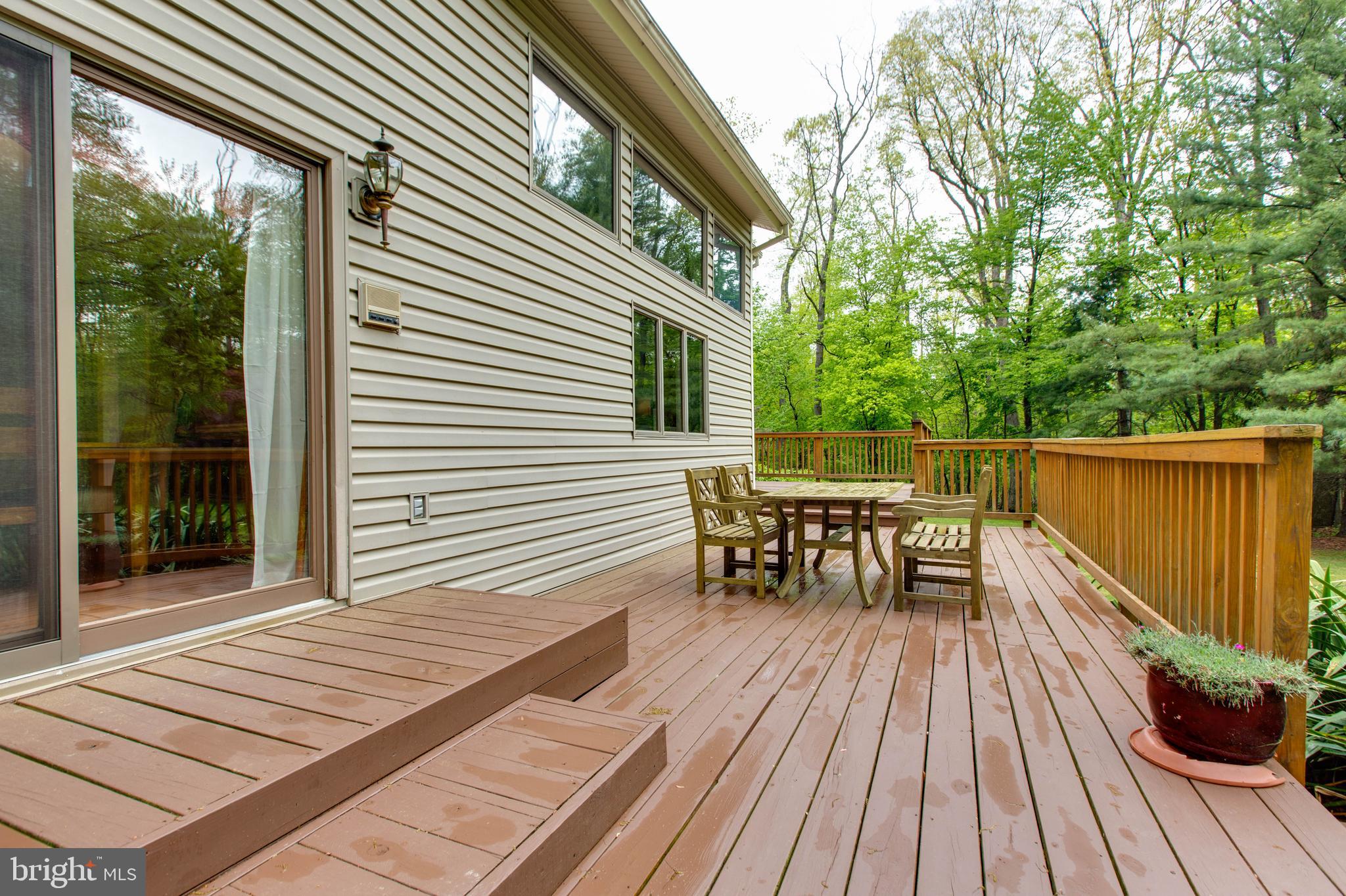 5519 Woodbine Road Sykesville, MD 21784 - Photo 51 of 69 a view of a roof deck with table and chairs floor to ceiling window with wooden floor