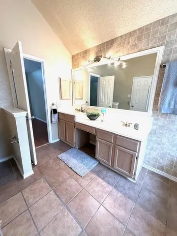 a view of an empty room with window and a kitchen