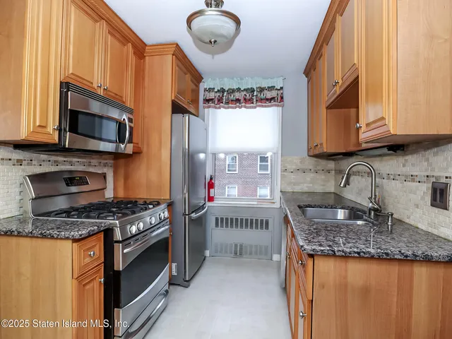a kitchen with stainless steel appliances granite countertop a stove sink and microwave