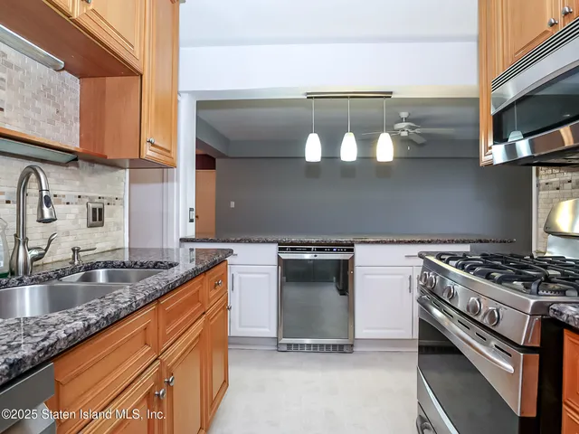a kitchen with stainless steel appliances granite countertop a sink and a stove