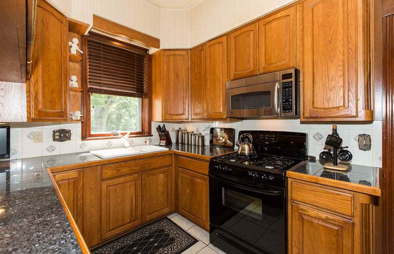 3604 Spring Creek Road Rockford, IL 61107 - Photo 9 of 24 a kitchen with stainless steel appliances granite countertop a stove a sink and a microwave