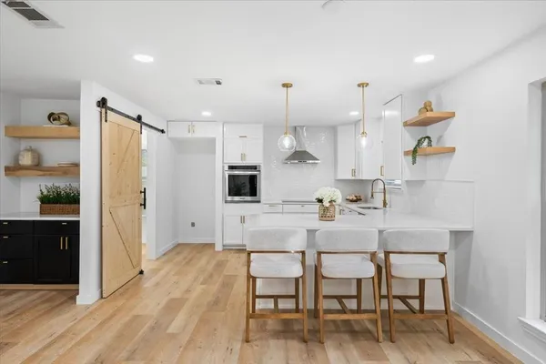 a kitchen with a dining table chairs refrigerator and cabinets