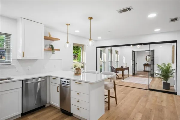 a kitchen with white cabinets stainless steel appliances and sink