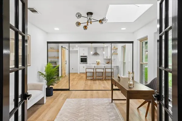 a view of a livingroom with furniture a floor to ceiling window and wooden floor