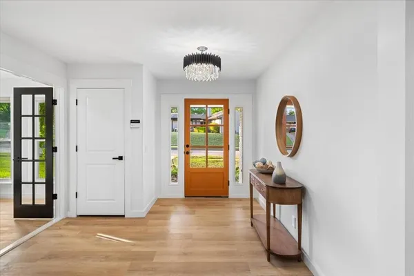 a view of a hallway with entryway wooden floor and front door
