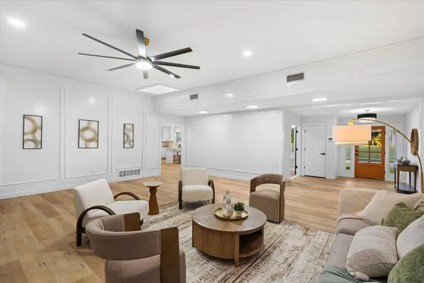a living room with furniture and a wooden floor