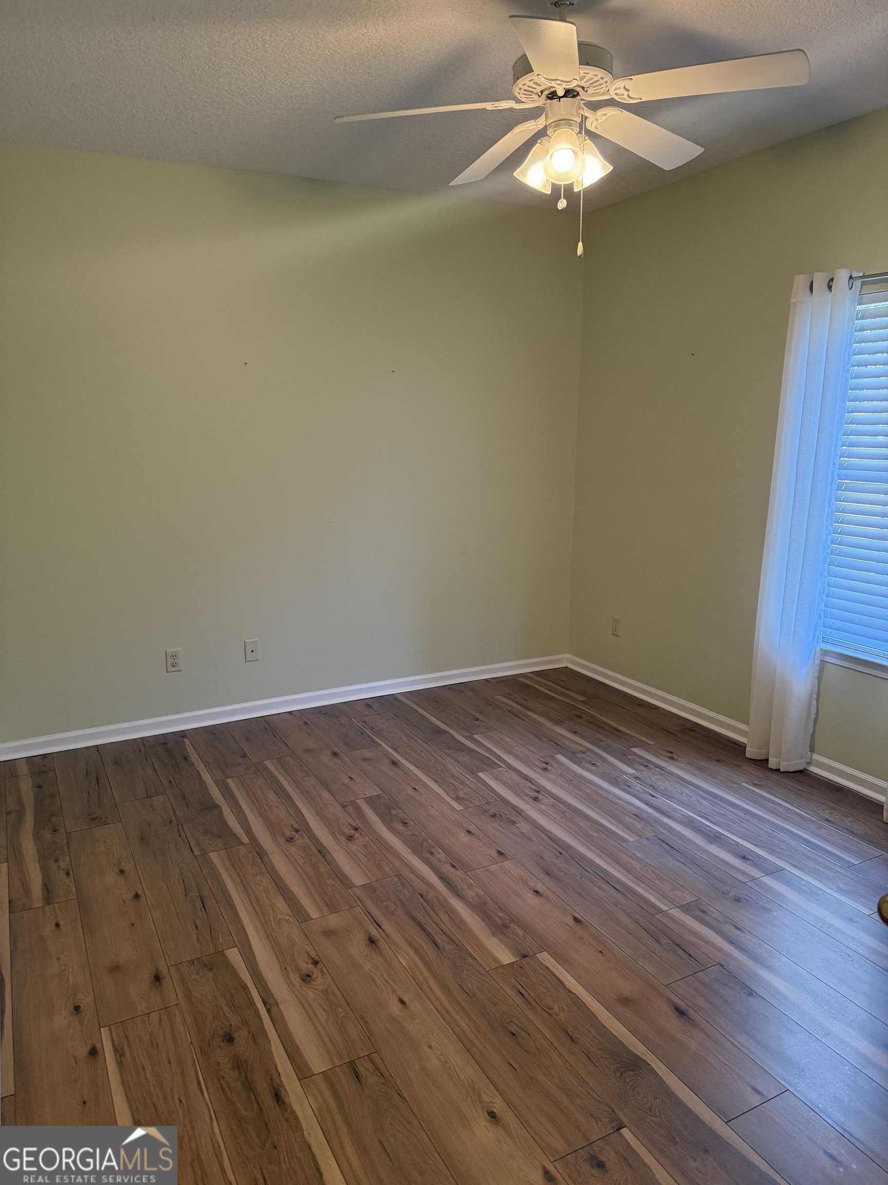 1403 Tanager Trail St. Marys, GA 31558 - Photo 11 of 24 a view of a room with wooden floor a ceiling fan and staircase