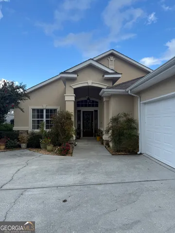 a view of a house with a yard and large tree