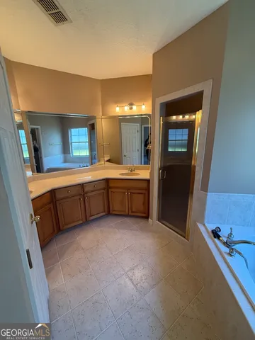 a large bathroom with a tub sink and mirror