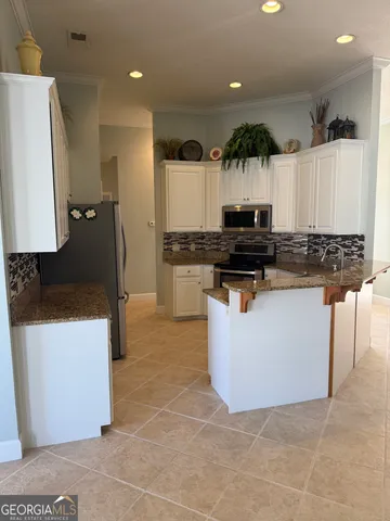 a kitchen with stainless steel appliances granite countertop a stove a sink a microwave and a refrigerator