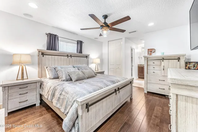 a bed room with a bed and a ceiling fan
