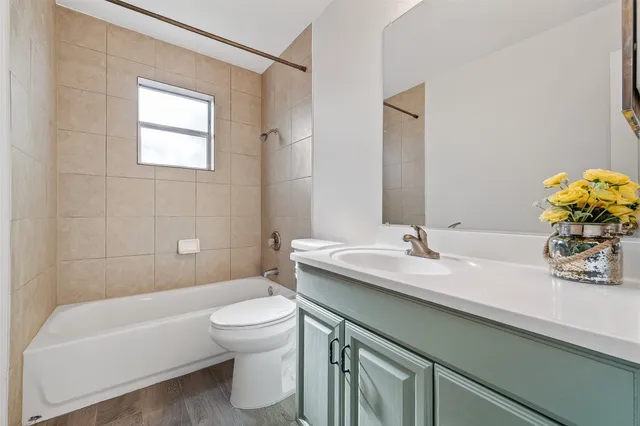 an empty room with wooden floor ceiling fan and windows