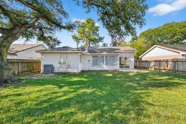 a view of a yard with a large tree and wooden fence