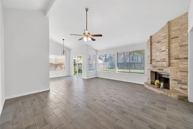 a view of empty room with wooden floor and ceiling fan