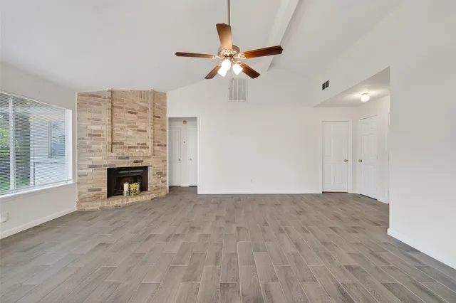 a view of a kitchen with a stove cabinets wooden floor and a ceiling fan