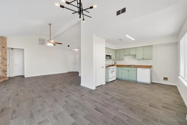 a view of empty room with wooden floor fireplace and fan